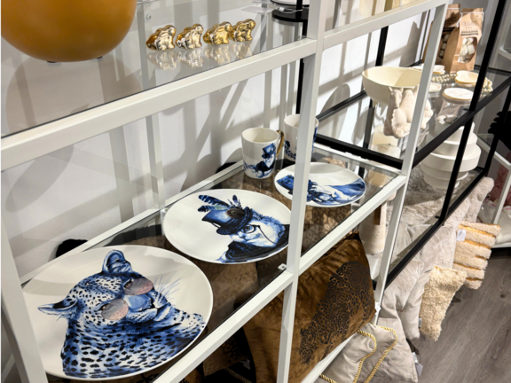 Regalierte Regale mit dekorativen Tellern, Kissen und verschiedenen Accessoires in neutralen Farben.